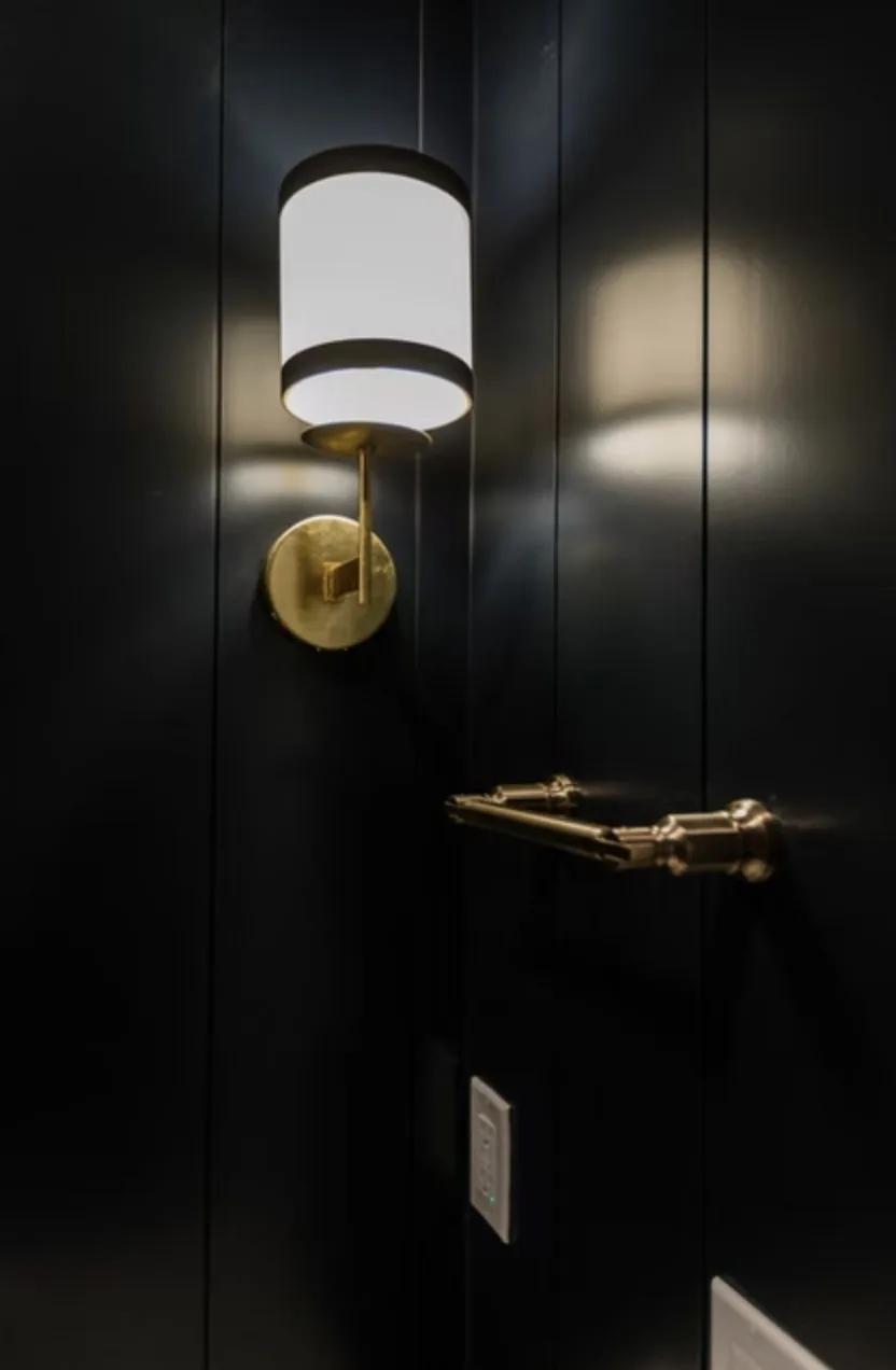 Brass sconce on a dark paneled wall